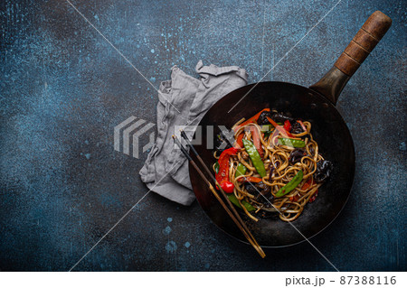 Asian stir fry noodles with vegetables in black wok pan copy space 87388116