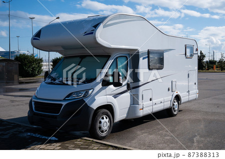 White house on wheels in the parking lot. 87388313