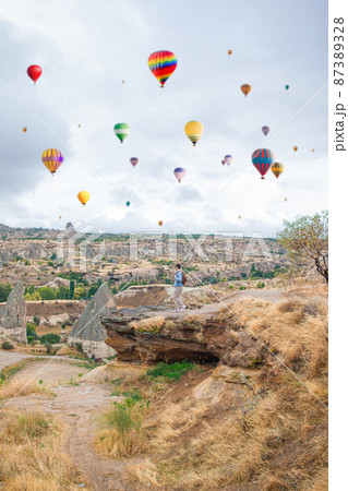 Happy young man watching hot air balloons in Cappadocia, Turkey Happy young man watching hot air balloons in Cappadocia, Turkey 87389328