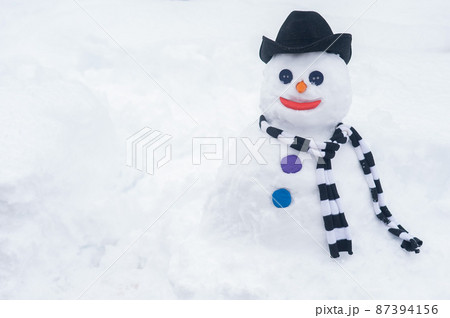 Snowman in a hat and a striped scarf. Winter fun. Snowman in a hat and a striped scarf. Winter fun. 87394156