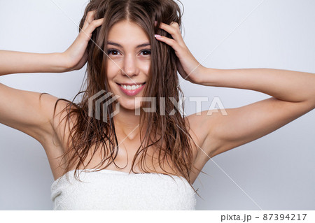 Happy young woman with wet hair in bathroom 87394217