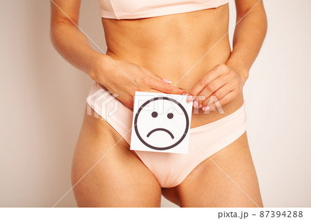 Female Body Holding Sad Smiley Card Near Stomach 87394288