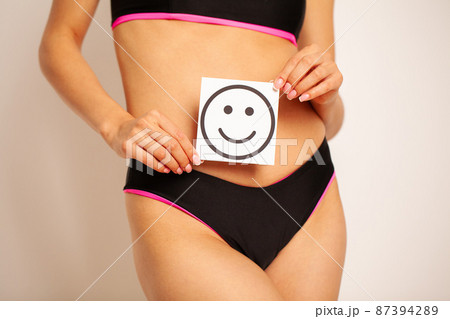 Closeup Of Healthy Female With Beautiful Fit Slim Body Holding Card With Happy Smiley Closeup Of Healthy Female With Beautiful Fit Slim Body Holding Card With Happy Smiley 87394289