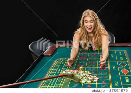 Young pretty women playing roulette wins at the casino 87394879