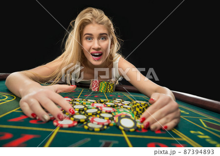 Young pretty women playing roulette wins at the casino 87394893