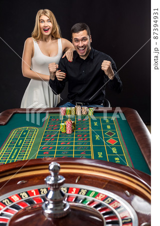 Couple playing roulette wins at the casino. 87394931