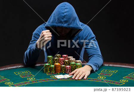 Portrait of a professional poker player sitting at pokers table Portrait of a professional poker player sitting at pokers table 87395023