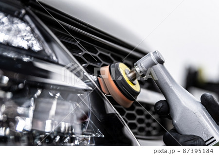 Car detailing technician polishing chrome shine decor on car 87395184