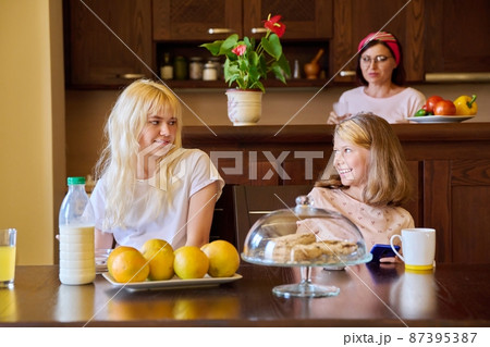 Children two sisters eating at home in the kitchen 87395387