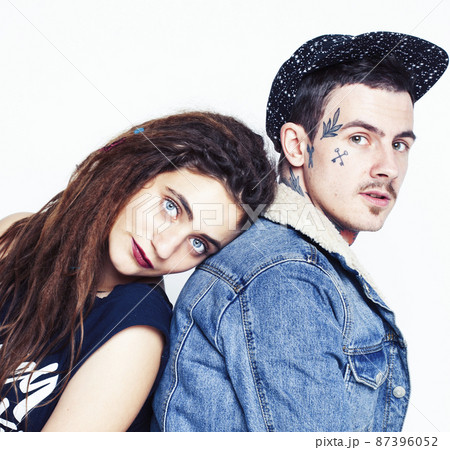 Young couple together. guy with tattoo, girlfriend wearing dreadlocks having fun on white background Young couple together. guy with tattoo, girlfriend wearing dreadlocks having fun on white background 87396052