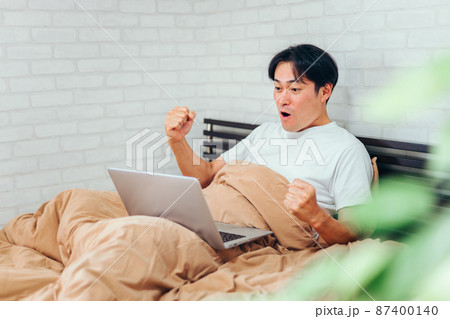 ノートパソコンに向かって応援する男性 87400140