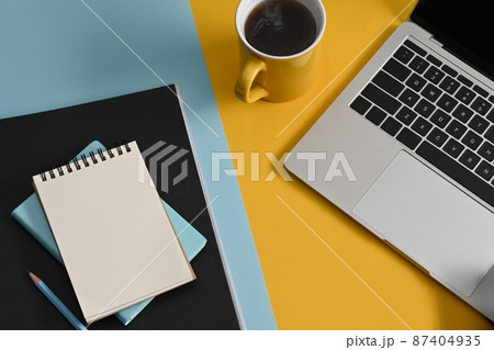 Top view notepad, computer laptop and coffee cup on colorful background. 87404935