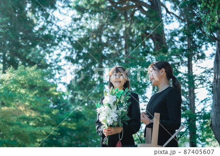 お葬式で笑顔で故人を送る遺族 87405607