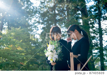 お葬式で泣く遺族と慰める日本人女性 87405609