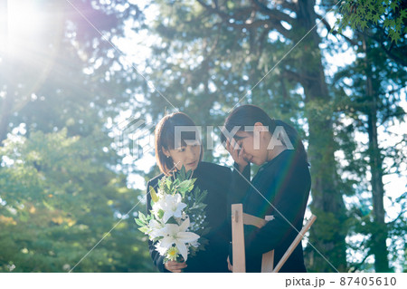 お葬式で泣く遺族と慰める日本人女性 87405610
