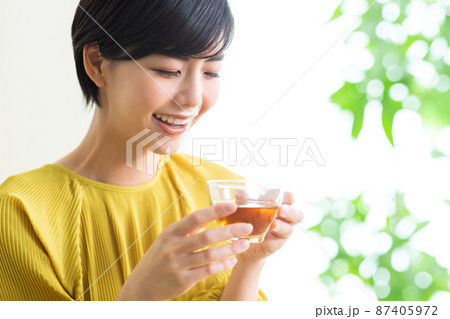 紅茶を飲む若い女性　飲み物　お茶　リラックス　健康　ティータイム 87405972
