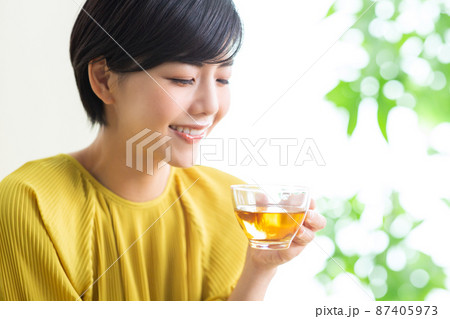 紅茶を飲む若い女性　飲み物　お茶　リラックス　健康　ティータイム 87405973