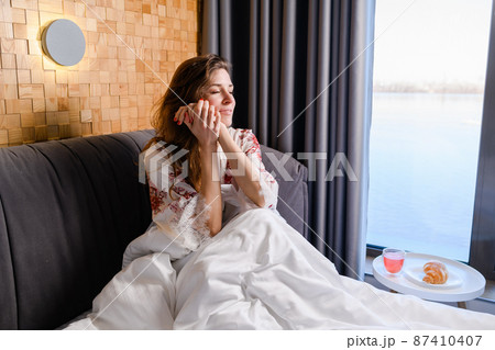 Young happy woman wakes up in morning. Young happy woman wakes up in morning. 87410407