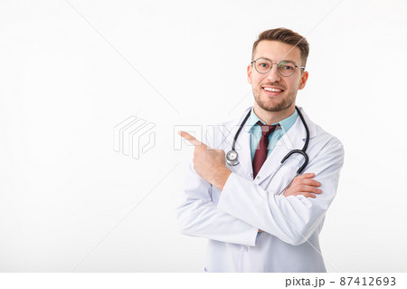 Portrait of confident young medical doctor on white background. Points to copy space Portrait of confident young medical doctor on white background. Points to copy space 87412693