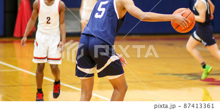 Basketball player bring the ball upcourt during a game 87413361
