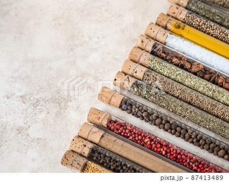 Various dry spices in glass tubes on textured background. Various dry spices in glass tubes on textured background. 87413489
