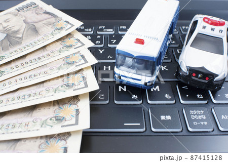 黒いキーボードと左側に並べられた1万円札と護送車とパトカー 87415128