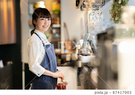 カフェのキッチンに立つ若い女性店員 87417003