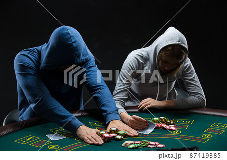 Poker players sitting at poker table and going all-in Poker players sitting at poker table and going all-in 87419385