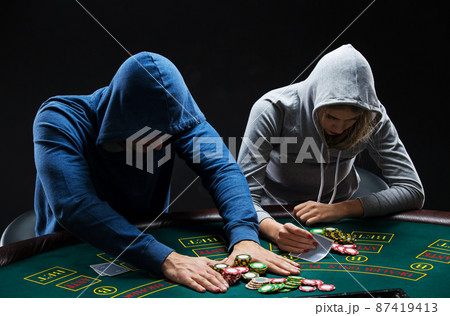 Poker players sitting at poker table and going all-in 87419413