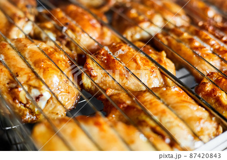 Grilled chicken thigh on the flaming grill. Close-up, selective focus Grilled chicken thigh on the flaming grill. Close-up, selective focus 87420843