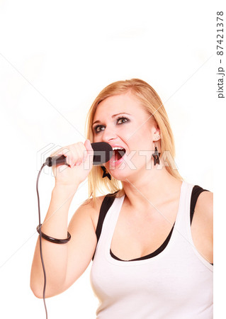 Blonde woman singing to microphone Blonde woman singing to microphone 87421378