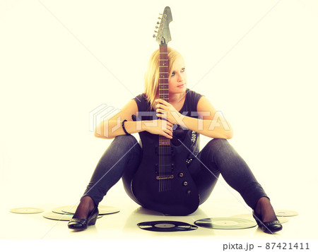 Woman with electrical guitar and vinyl record. Woman with electrical guitar and vinyl record. 87421411