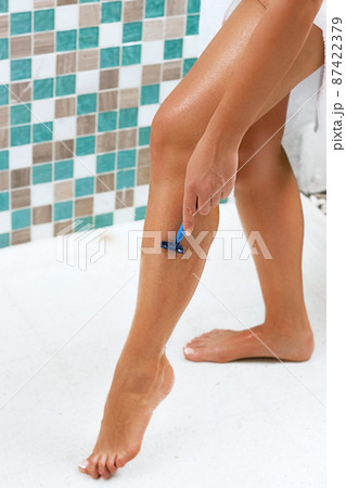 Beautiful woman is shaving her leg. Wet feet, women legs in the shower. Beautiful woman is shaving her leg. Wet feet, women legs in the shower. 87422379