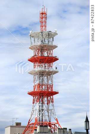 街中にそびえ立つ鉄骨トラス構造の通信用電波塔 87422833