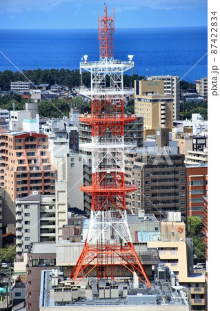 街中にそびえ立つ鉄骨トラス構造の通信用電波塔 87422834