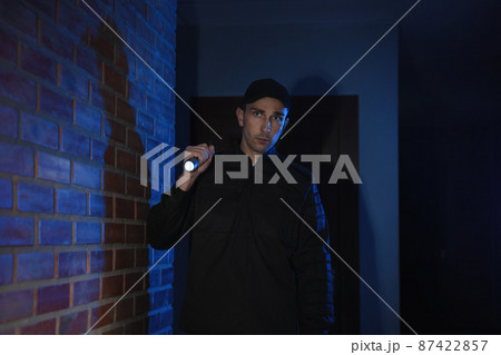 Male security guard with flashlight in dark corridor Male security guard with flashlight in dark corridor 87422857