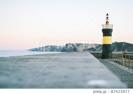 View to the lighthouse, crag and ocean. 87423977