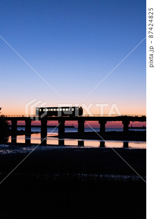 マジックアワーに染まった空の下宮崎県日南市日南海岸山王浜を走る一車両のJR九州キハ40日南線通勤列車 87424825