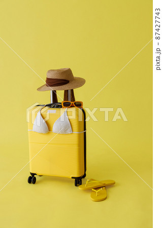 Travel bag, straw hat, sunglasses, flip flops and bra in studio Travel bag, straw hat, sunglasses, flip flops and bra in studio 87427743