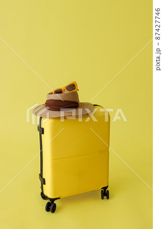 Travel suitcase, straw hat and sunglasses in studio Travel suitcase, straw hat and sunglasses in studio 87427746