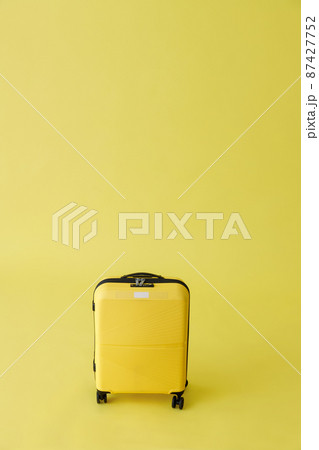 Yellow travel suitcase or trolley luggage bag in studio 87427752