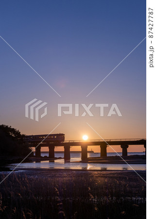 マジックアワーと共に昇る日出の宮崎県日南市山王の日南海岸山王浜を走るJR九州キハ40日南線通勤列車 マジックアワーと共に昇る日出の宮崎県日南市山王の日南海岸山王浜を走るJR九州キハ40日南線通勤列車 87427787