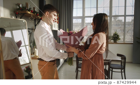 A young man gives flowers to his girlfriend. Romance A young man gives flowers to his girlfriend. Romance 87429944