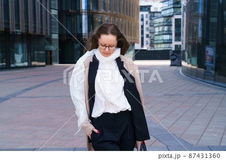 Female portrait of a business woman wearing glasses at the business center 87431360