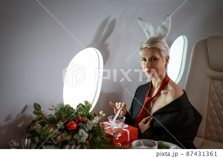 beautiful young woman with bunny ears in a private jet beautiful young woman with bunny ears in a private jet 87431361