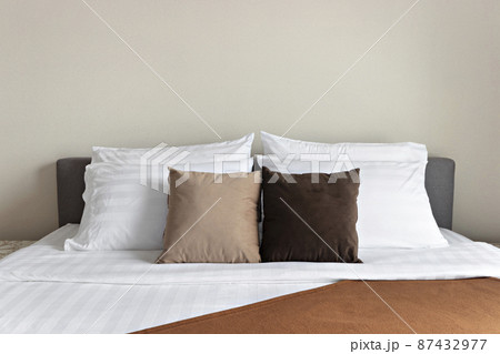Many soft pillows on comfortable bed indoors Many soft pillows on comfortable bed indoors 87432977