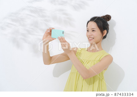 スマホを持つ女性 白背景 スマホを持つ女性 白背景 87433334