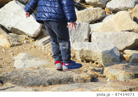 岩場で立ちすくむ子供(3歳児/男の子) 87434073