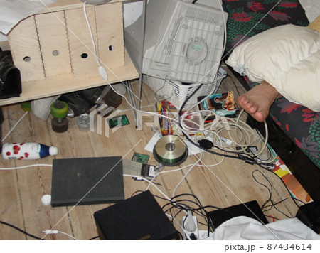 Student digs - Lifestyle - A teenagers room. A candid image of a messy bedroom with a foot sticking out from under the bed covers. 87434614
