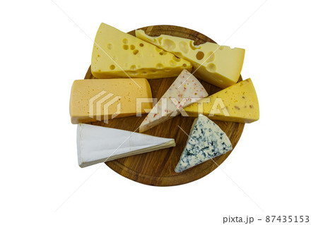 Set of various types of cheese on wooden cutting board isolated on white background. Top view 87435153
